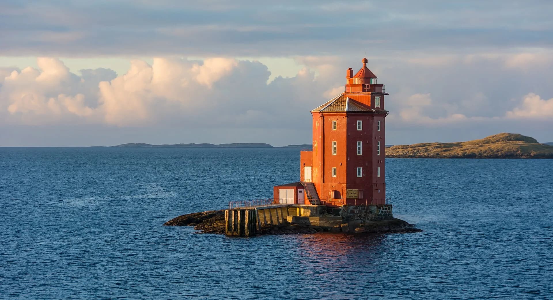 Kjeungskjær Lighthouse on a rock in the sea at sunset, Norway