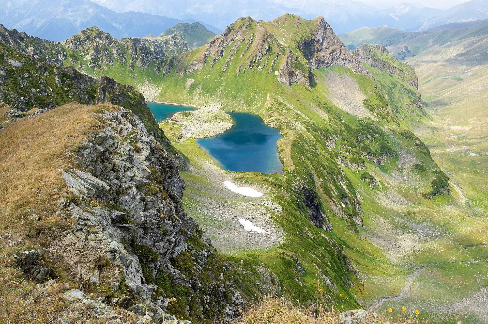 Green mountain ridge above a blue alpine lake
