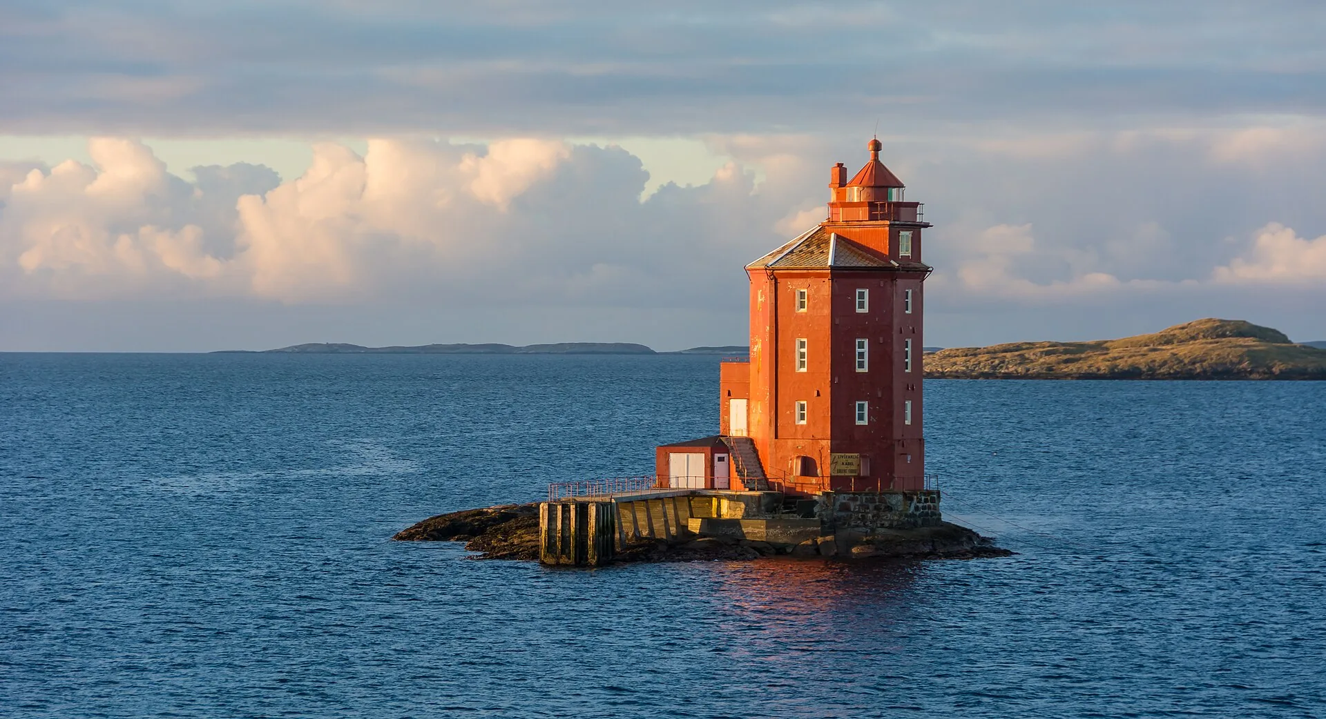 Kjeungskjær Lighthouse on a rock in the sea at sunset, Norway